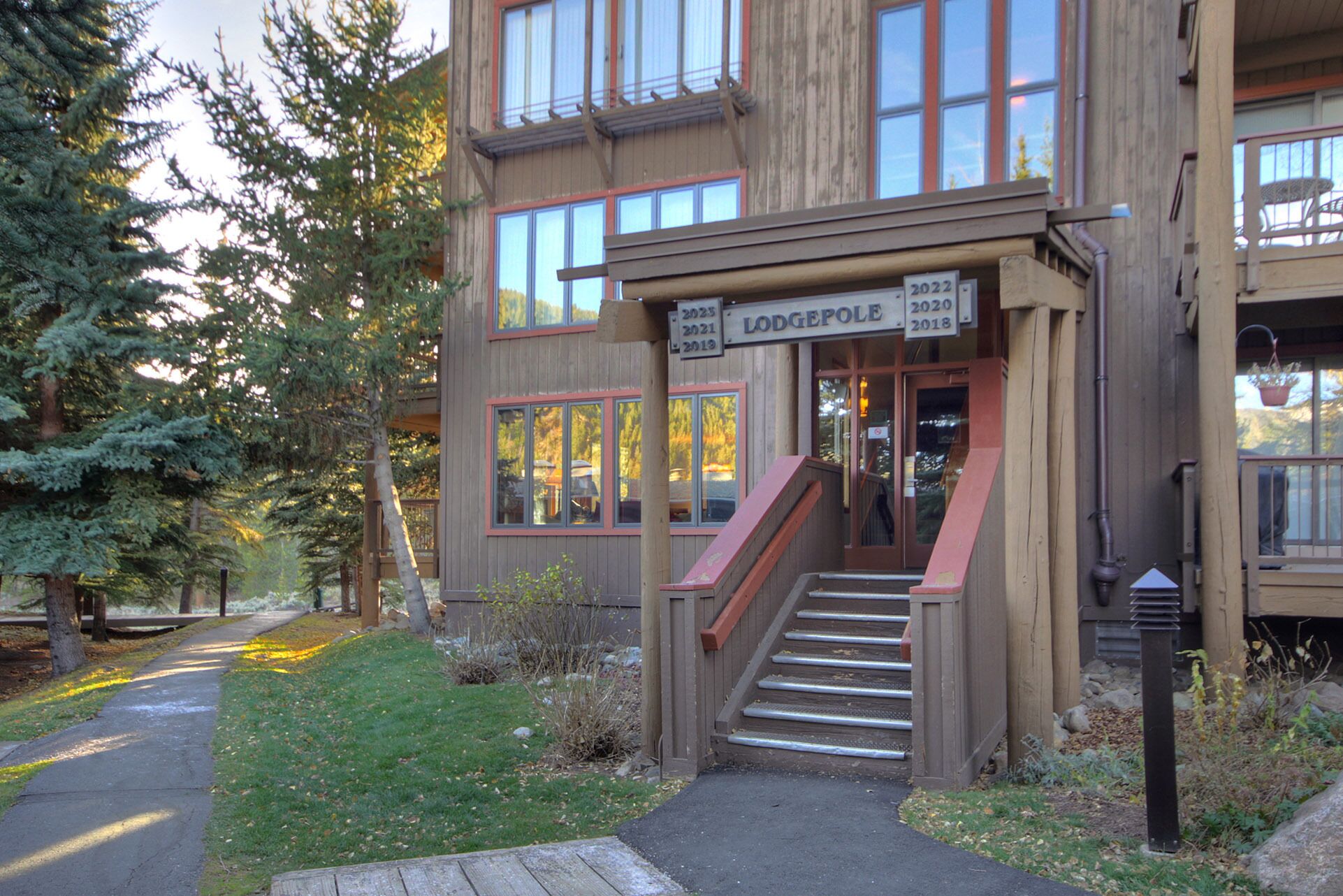 A lodge with a wooden exterior, a staircase leading to the entrance, and a sign indicating the years of operation.
