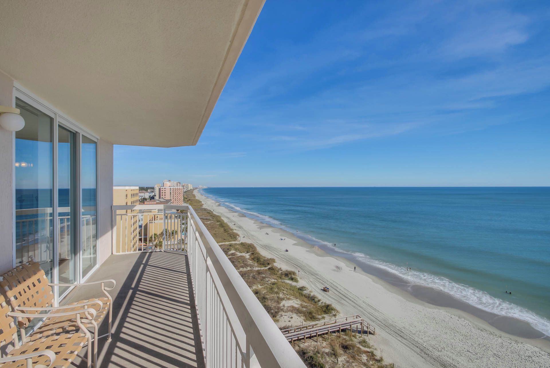 A balcony with a view of a beach and ocean.