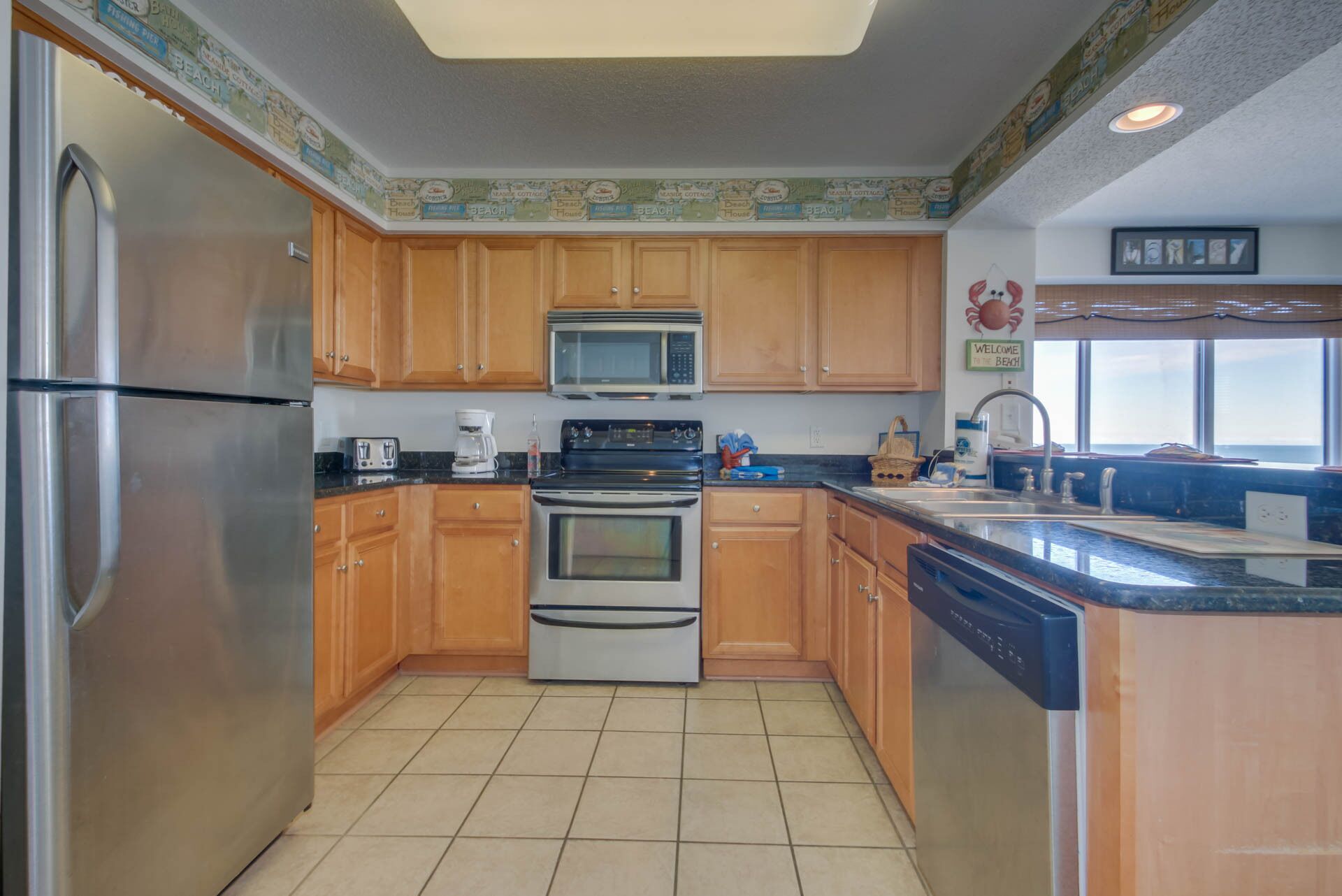 A kitchen with wooden cabinets, stainless steel appliances, and a tiled floor.