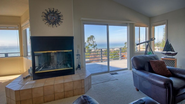 A living room with a fireplace, a leather sofa, and a telescope. - Heavenly Ocean View - #LH37: 2  BR, 2  BA House in Cambria, Sleeps 4 (Cambria)