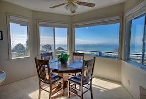 Enjoy meals with a view of the ocean from this dining area featuring a round table and four chairs.