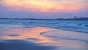 Una spiaggia con onde e un cielo al tramonto.
