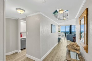 Een modern interieur met een keuken, een eetgedeelte en uitzicht op zee.