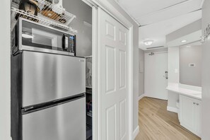 Een moderne keuken met een roestvrijstalen koelkast, een magnetron en een inbouwoven.