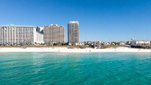 A beachfront hotel with multiple high-rise buildings, a sandy beach, and clear blue waters. - 2 Free Beach SRVCS- 4 chairs/2 umbrellas! Free Beach Bonfires M/F nts (Miramar Beach)