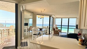 A spacious kitchen with a large island, a dining area with white chairs, and a view of the ocean. - 2 Free Beach SRVCS- 4 chairs/2 umbrellas! Free Beach Bonfires M/F nts (Miramar Beach)