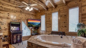 A wooden cabin interior with a stone bath, a television, and a coffee machine. - ERN834 - LAKESIDE GETAWAY - GREAT LOCATION!  CLOSE TO ALL THE ACTION! (Pigeon Forge)