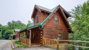 A log cabin with a porch and a sign indicating it is a lakeside getaway. - ERN834 - LAKESIDE GETAWAY - GREAT LOCATION!  CLOSE TO ALL THE ACTION! (Pigeon Forge)