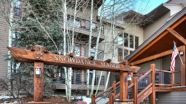 A wooden sign with "SNOWDANCE MANOR" written on it, indicating the name of the building. - Centrally Located/Walk to Lifts/Pool and Hot Tub Access/Private Patio (Keystone)