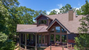A modern house with a large deck, a covered porch, and a chimney. - View House  - Stunning Views of Mountains and Yadkin River, huge deck, wood burning fireplace (Boone)