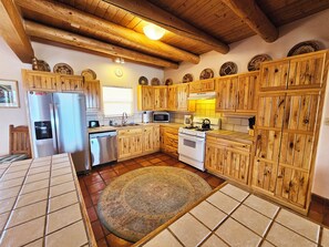 A kitchen with wooden cabinets, a refrigerator, a stove, and a microwave.