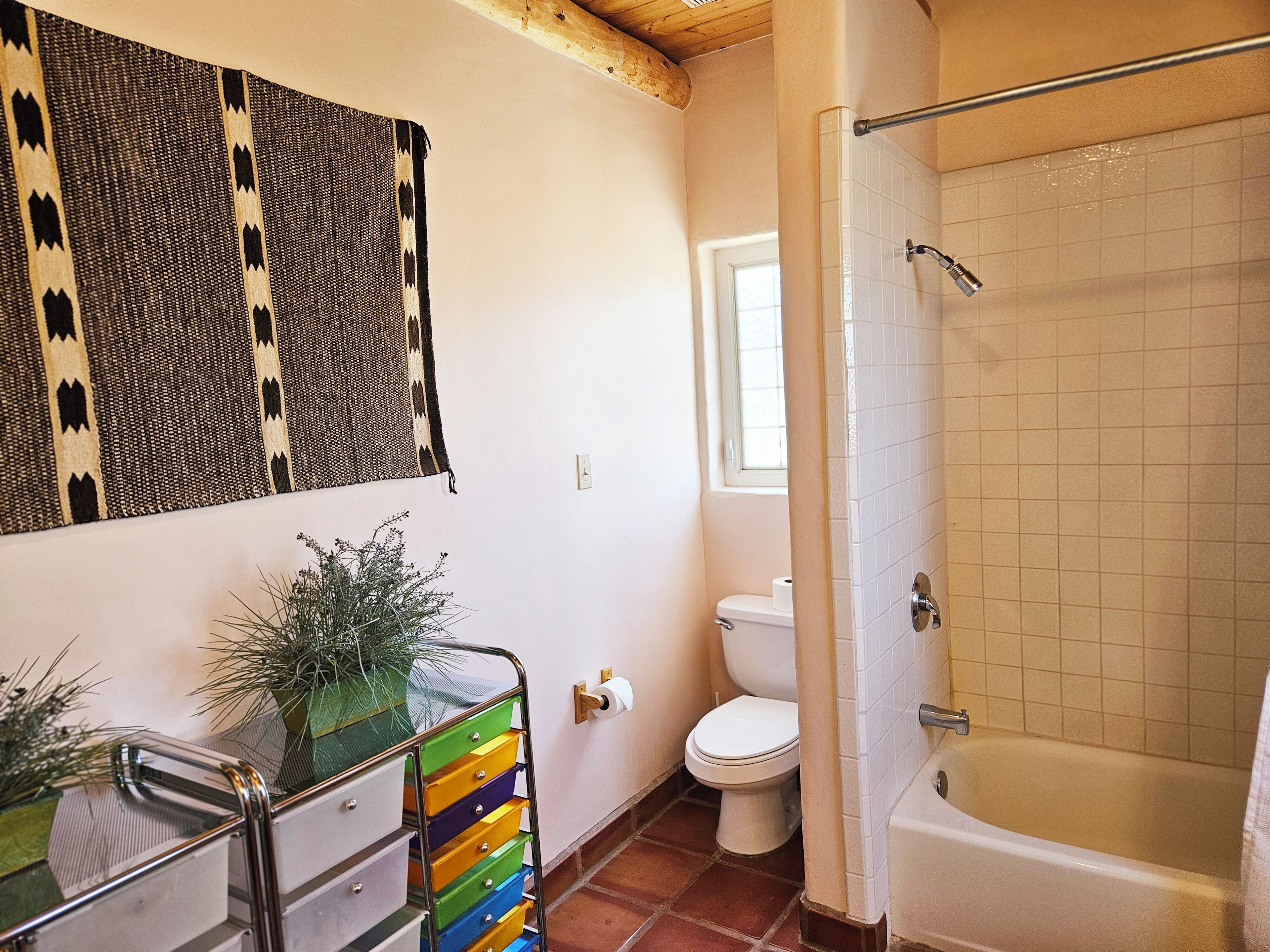 A bathroom with a shower, toilet, and a towel rack.