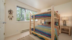 A bunk bed room with a window, a dreamcatcher, a lamp, and a rug. - JHRL - Balsam Lodge A8 - Great Location in the Aspens (Wilson)