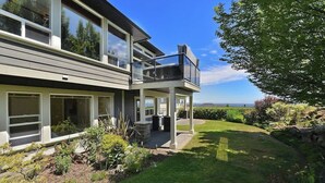 A modern two-story house with a balcony, large windows, and a well-maintained garden. - Nature's Gate Executive Estate (Victoria)