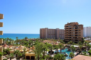 Een resort met meerdere gebouwen, een zwembad en palmbomen.