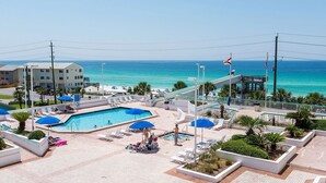 Ein Poolbereich eines Resorts mit mehreren Pools, Sonnenschirmen und Liegestühlen.
