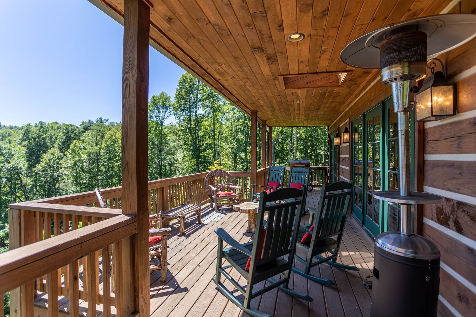 Eine Holzterrasse mit Sitzgelegenheiten im Freien, einem Grill und einem Mülleimer.