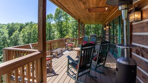 A wooden deck with outdoor seating, a grill, and a trash can. - Gratitude - Hot Tub, Pool Table, Covered Decks, 5 minutes to Boone (Blowing Rock)