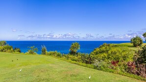 A golf course with a view of the ocean and a clear sky. - Pali Ke Kua 245 .. Updated Oceanfront Condo, Views are Expansive! (Princeville)