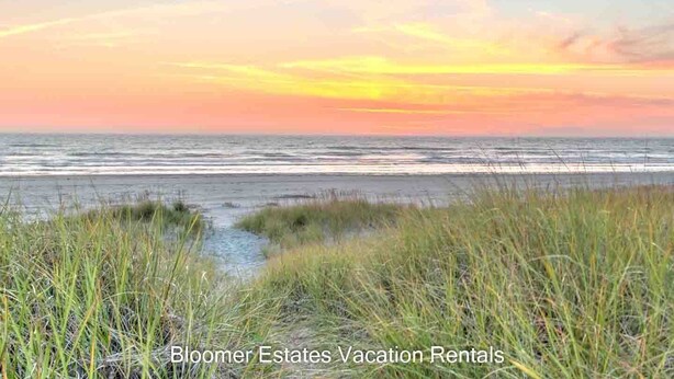 A beach with grass in the foreground and a sunset in the background. - PICKLEBALL, HOT TUB, Dogs Ok, Ocean View, Playset (SV1) (Long Beach)