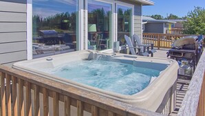 A hot tub in a wooden deck area with a view of a house and outdoor furniture. - PICKLEBALL, HOT TUB, Dogs Ok, Ocean View, Playset (SV1) (Long Beach)