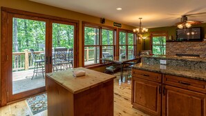 A spacious kitchen with large windows, a wooden deck, and a stone fireplace. - A Peak of Heaven 1 mi from Blue Ridge Parkway very private ping pong table (Boone)
