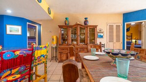 A dining area with a wooden table, chairs, and colorful decorative elements.