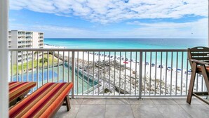 A balcony with a view of a beach and a tennis court. - 603- Gulf Front with the Best Sunrise View, Plus FREE Beach Service (Destin)