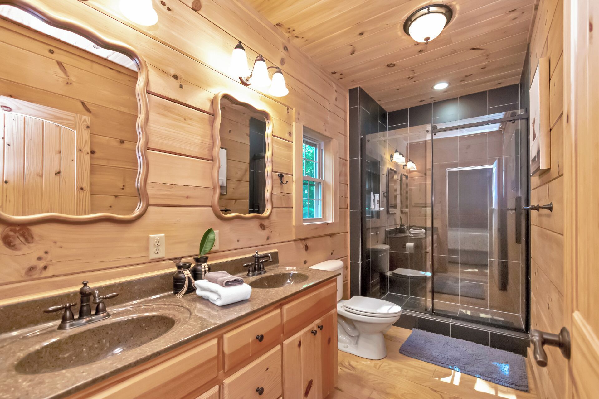 Baño de cabaña de madera con lavamanos, inodoro y ducha.