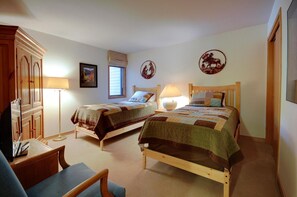 A bedroom with two wooden beds, a desk, a chair, a wardrobe, and two wall-mounted lamps. - Ski Run Condo with Ski Run Views off deck, 3min walk to base, private entrance (Keystone)