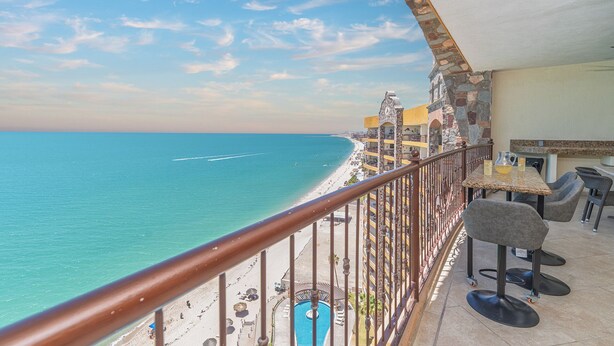 Ein Balkon mit Blick auf Strand und Meer.