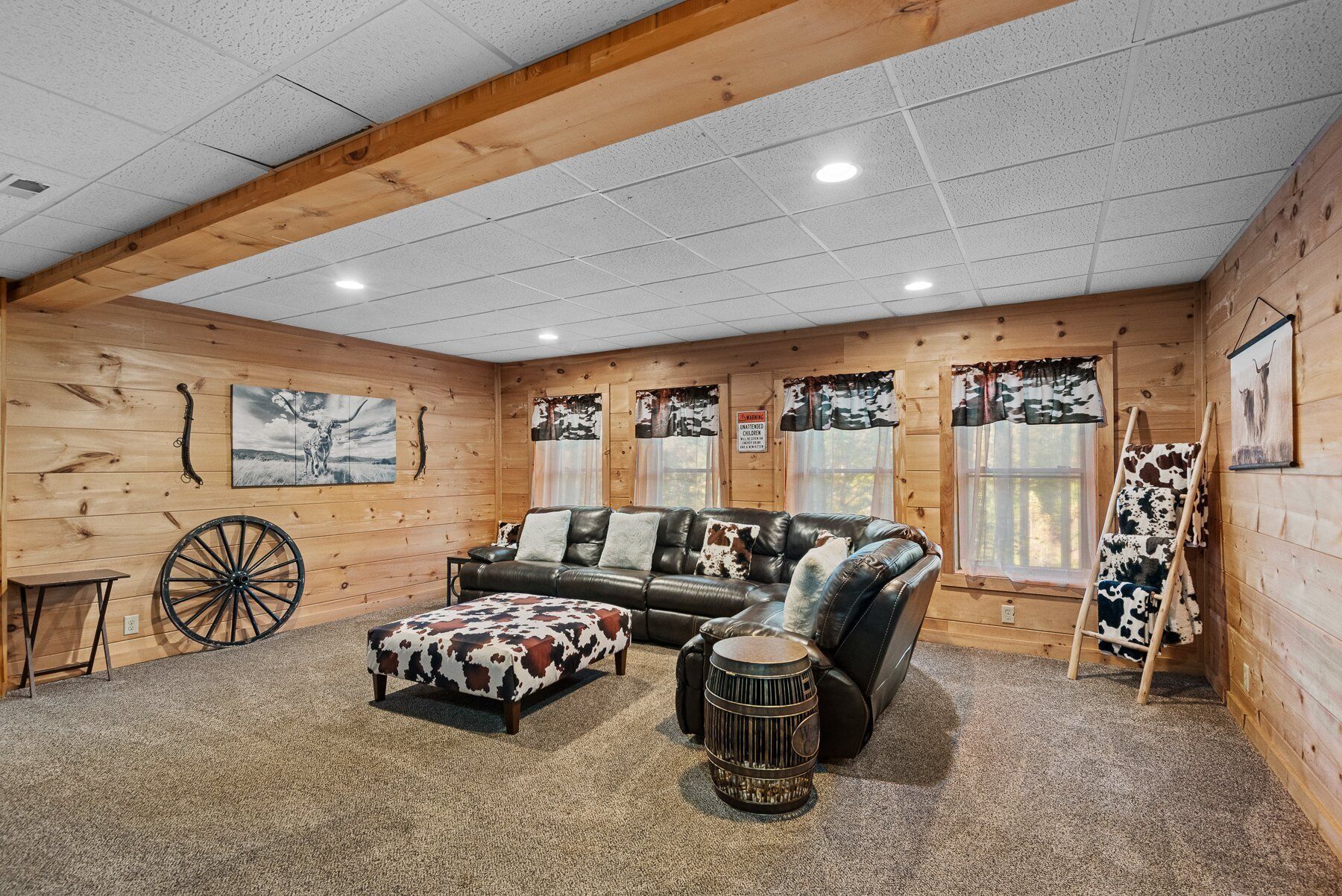 A cozy cabin interior with a leather sofa, a wooden rocking chair, and a rustic decor theme.