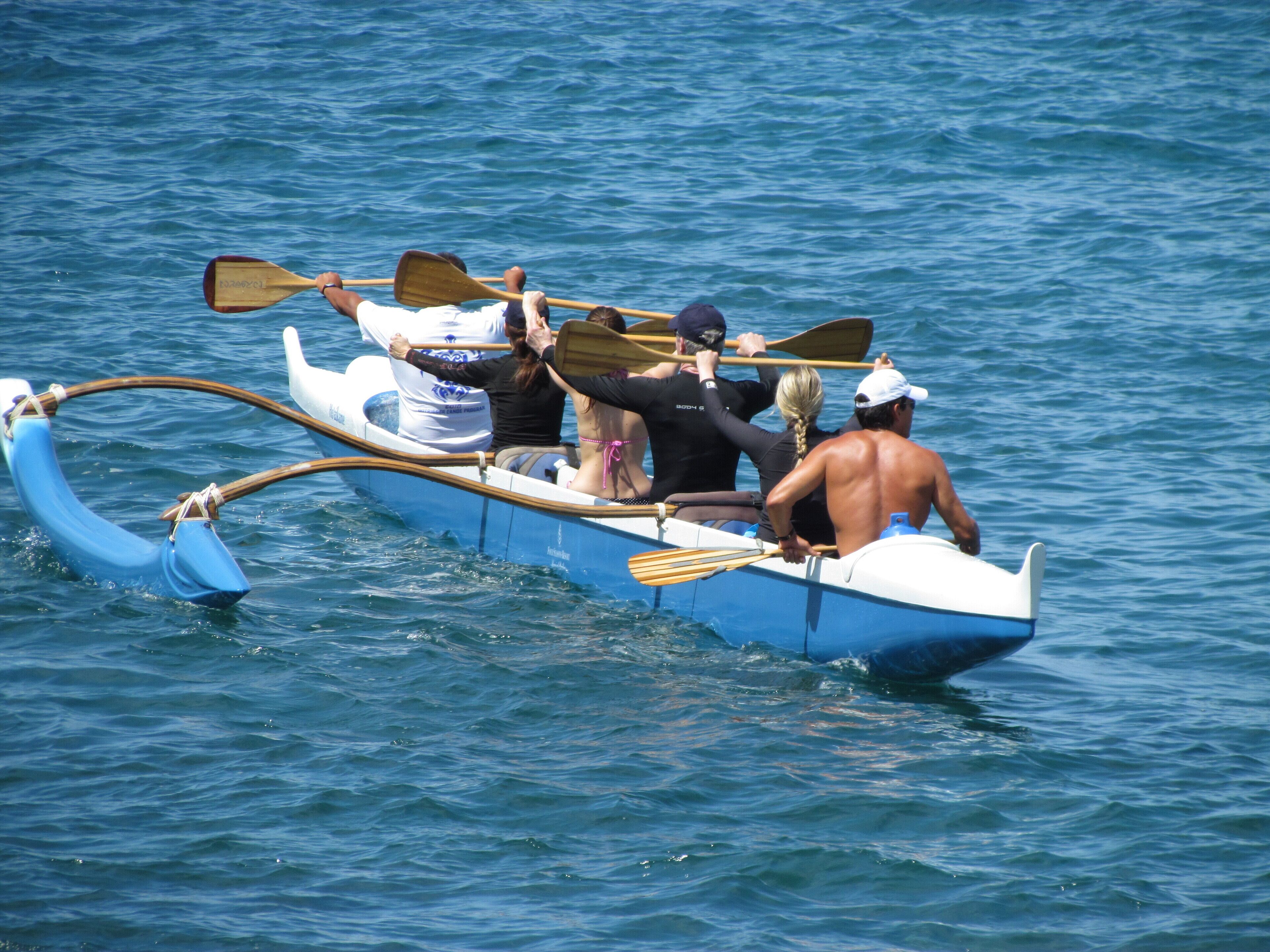 Un bote para remar con cuatro personas, una remando y tres pasajeros.
