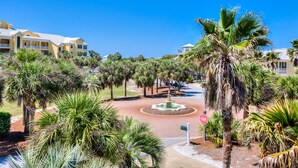 A resort area with palm trees, a fountain, and a stop sign. - Alabama Sunrise- 3BR/3BA crescent beach home - Pet Friendly (Gulf Shores)