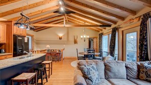 A spacious living room with a large sofa and a dining area with wooden furniture.