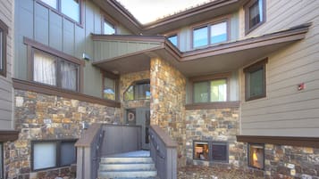 A multi-story building with a stone facade, a central staircase, and multiple windows.