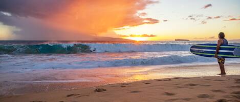 A beach scene with waves and a sunset.