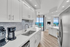 A modern kitchen with white cabinetry, a built-in dishwasher, and a coffee maker. - 2 Free Beach Svc=4 Chairs/2 Umbrellas! Free Beach Bonfires M/F nts! AWESOME View (Miramar Beach)