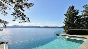 Une vue dégagée sur une piscine à débordement, avec une chaîne de montagnes en arrière-plan.