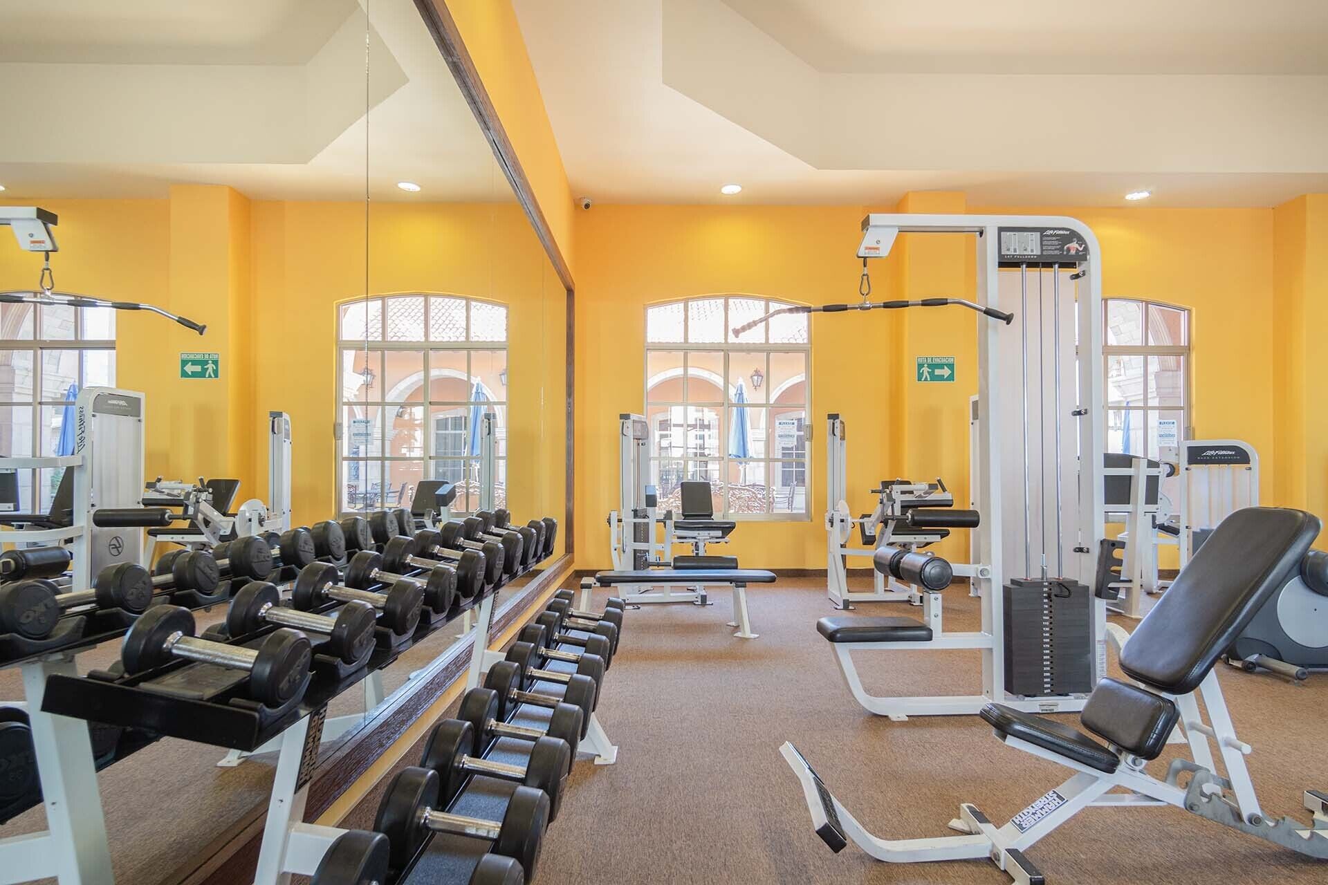 Ein Fitnessstudio mit Krafttrainingsgeräten, Trainingsmaschinen und Hanteln.