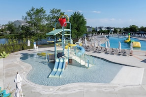 Un parque acuático con piscina, toboganes y estructuras de juego.