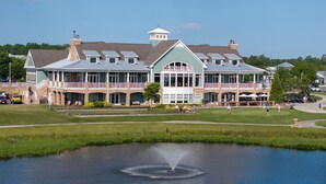 A large building with multiple balconies and a pond in front.