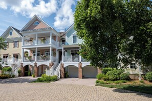 A multi-story residential building with a central staircase, multiple balconies, and a brick facade. - 22096 S Preservation Drive (Millsboro)