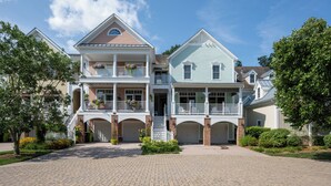 A two-story house with a front porch, a garage, and a driveway.