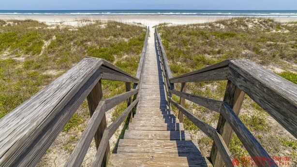 A wooden boardwalk leading to a beach with sand dunes and ocean in the background. - Modern Beach Retreat ~ Close to the Beach! (Saint Augustine)
