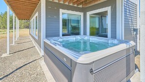 A hot tub under a wooden pergola with a view of a house. - PICKLEBALL, NEW HOT TUB, Ocean View, Playset (SV2) (Long Beach)