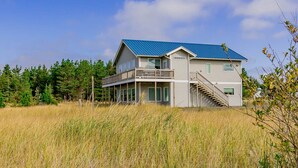 A two-story house with a blue roof, a balcony, and a staircase leading to the upper level. - PICKLEBALL, NEW HOT TUB, Ocean View, Playset (SV2) (Long Beach)