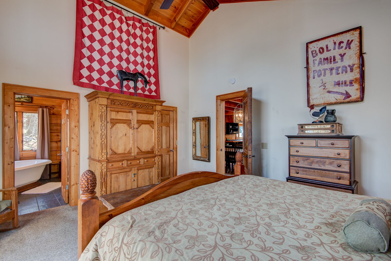Ein Schlafzimmer mit einem großen Bett, einem Holzschrank und einem Wandbehang mit roten und weißen Karos.