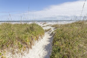A sandy path leading to a beach with dunes and sparse vegetation. - Spacious Condo ~ Excellent Location ~  Steps to the Beach (Saint Augustine)