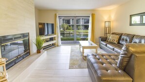Uma sala de estar moderna com lareira, sofá de couro e televisão.